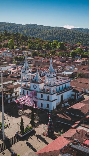 Vista aérea de Mazamitla con una iglesia blanca y colinas cubiertas de pinos