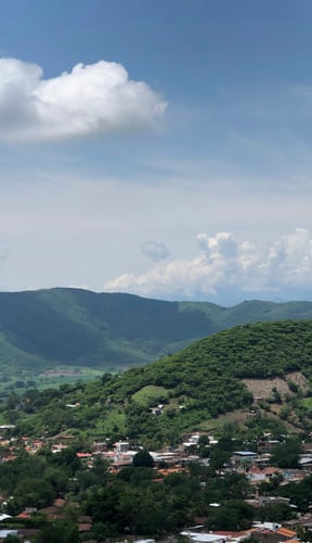 Vista aérea de colinas verdes y un pueblo en Jalisco